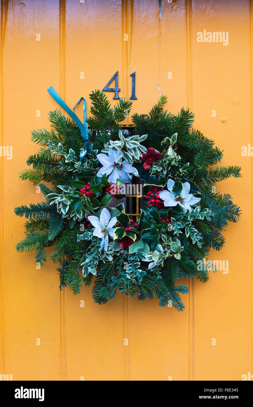 Christmas wreath on a yellow coloured wooden door Stock Photo