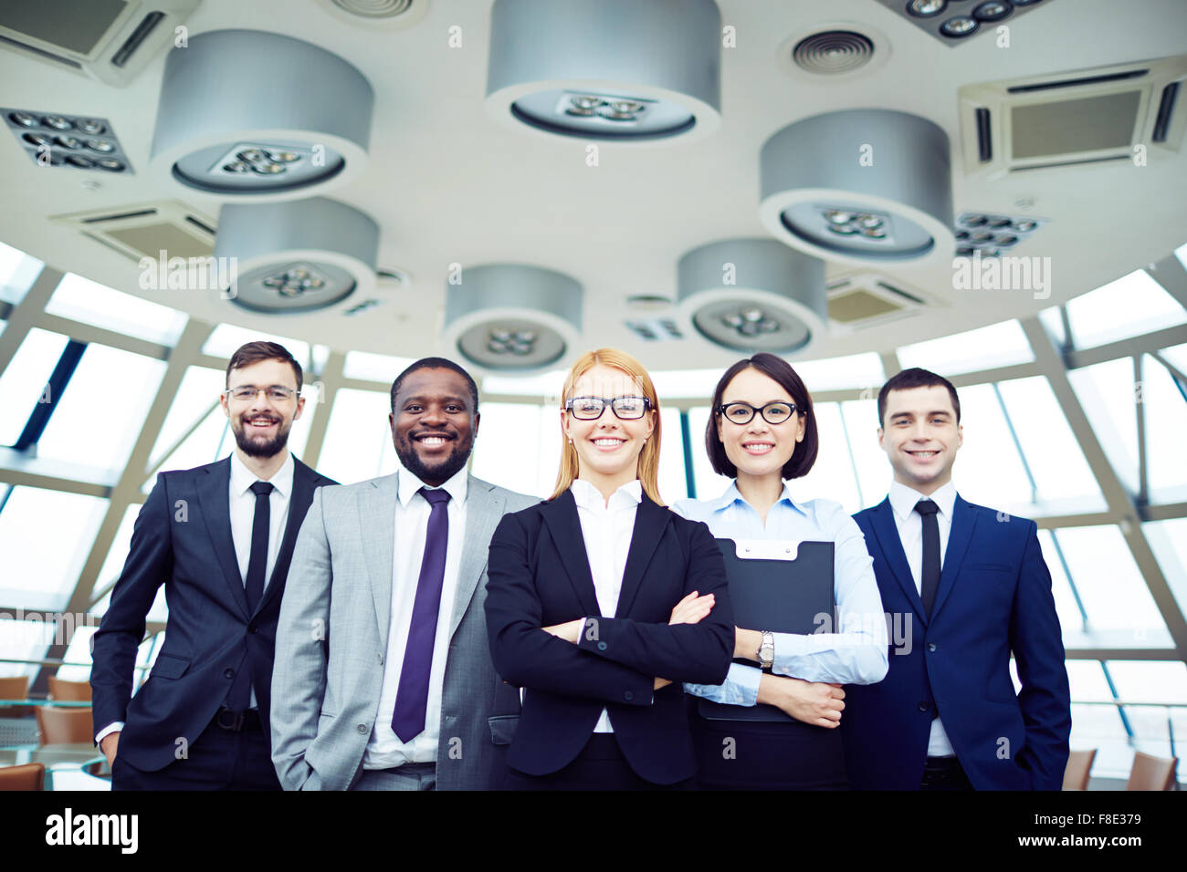 Portrait of smiling business team standing at office Stock Photo - Alamy