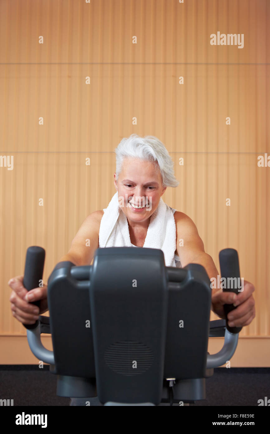 Elderly woman exercising on bicycle in a gym Stock Photo - Alamy