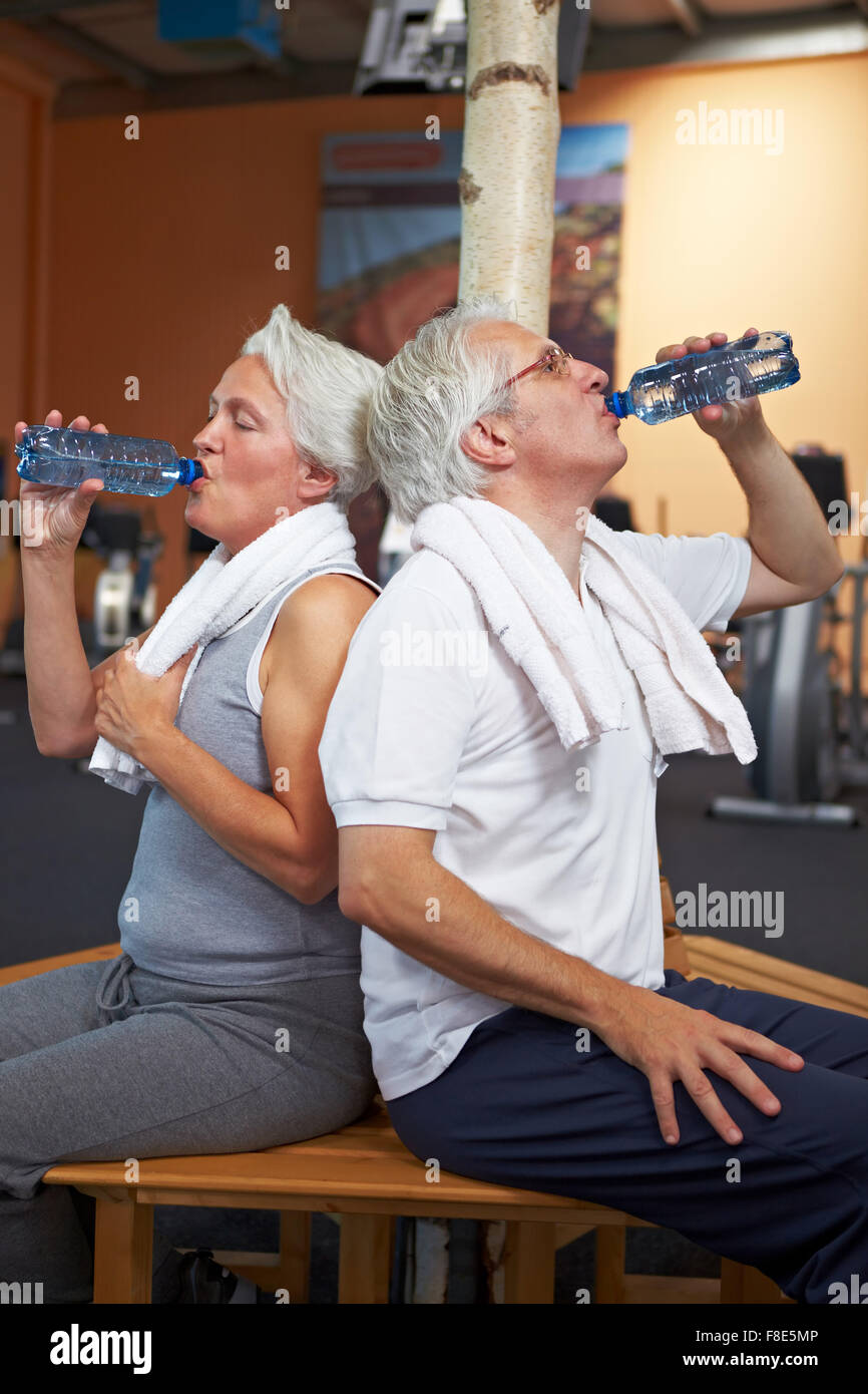 Two senior people in a gym drinking water Stock Photo