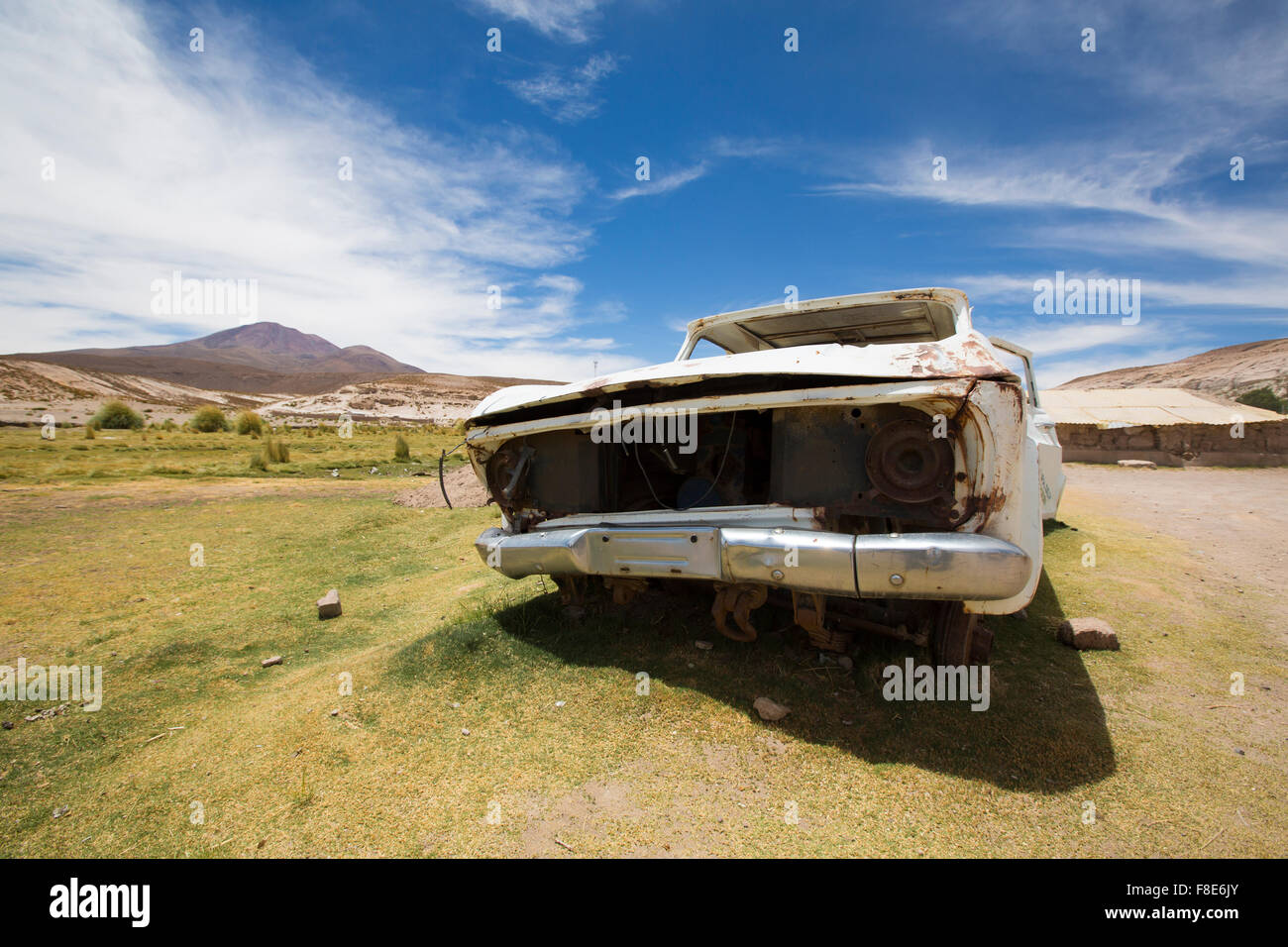 Rusted white old car left in the countryside with green grass and ...