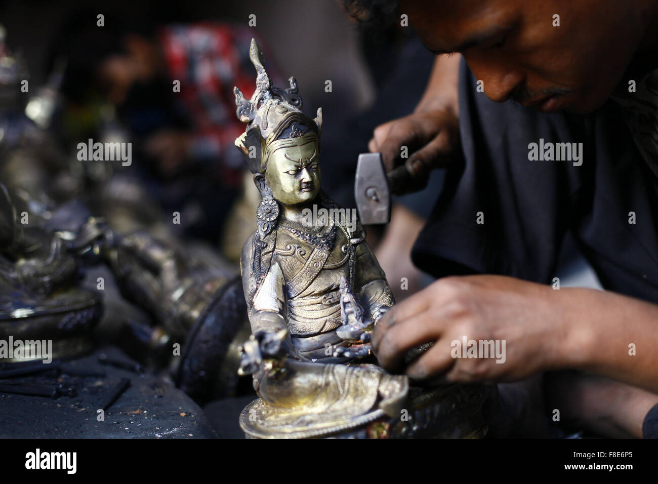 Lalitpur, Nepal. 8th Dec, 2015. A Nepalese artist makes metal sculpture