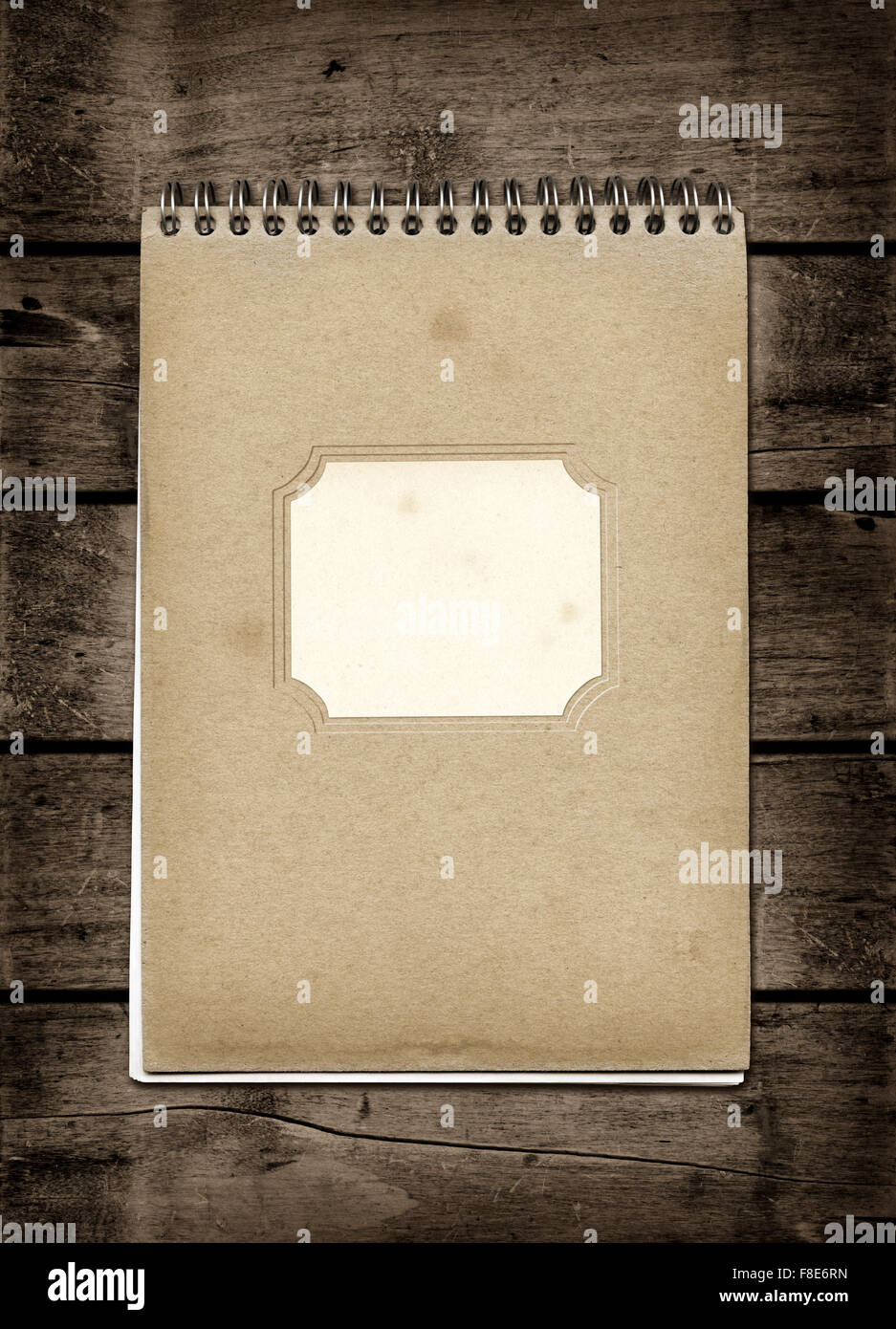 Closed spiral Note book on a dark wood table. Mockup Stock Photo