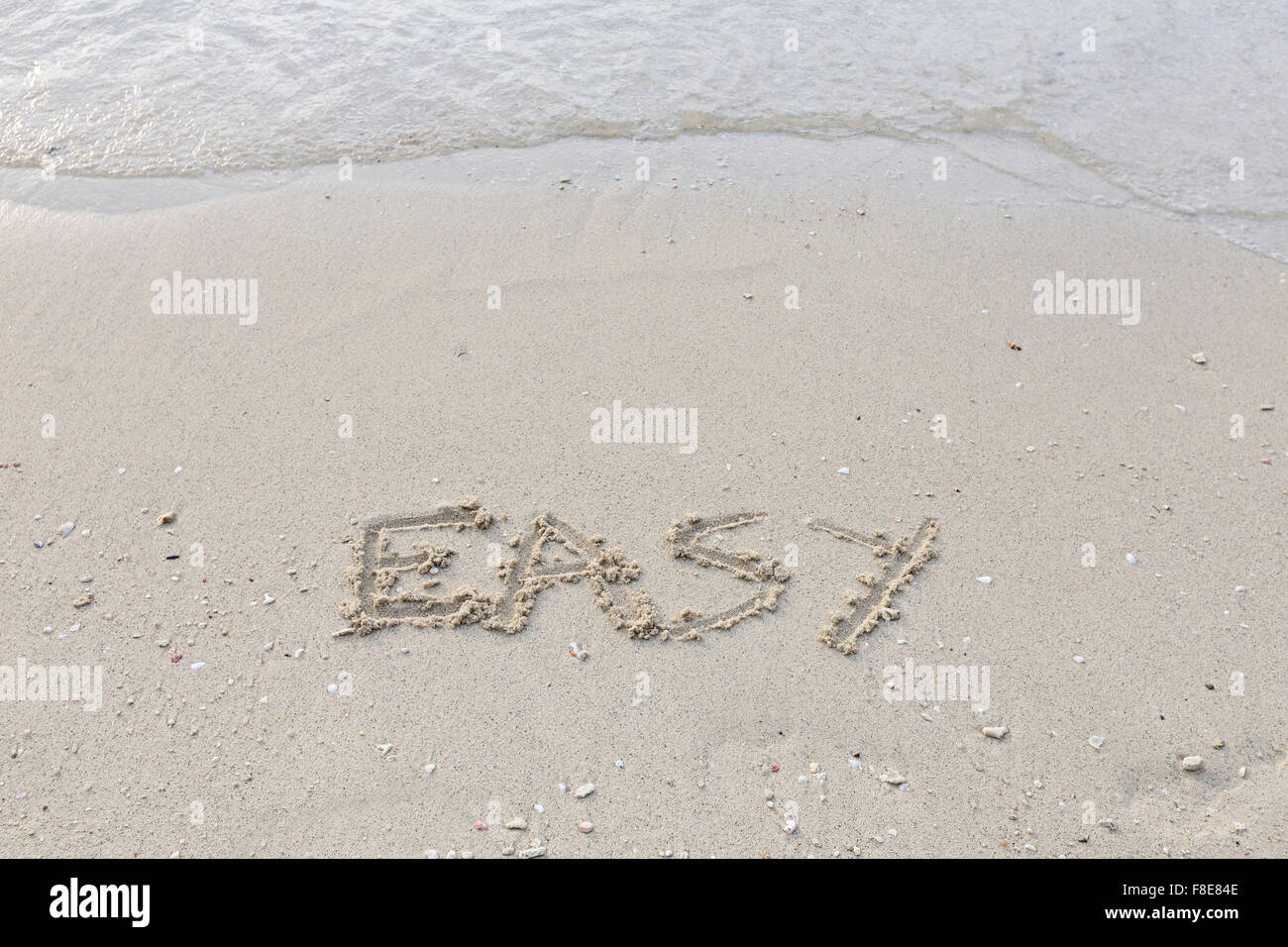 Easy written out in wet sand Stock Photo
