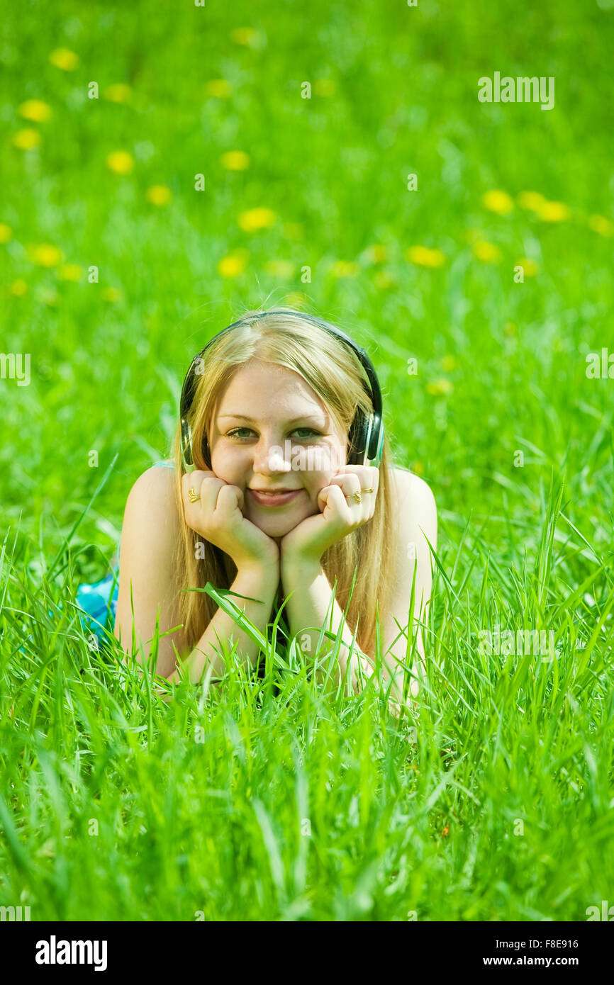 teen girl listening music and lying on grass Stock Photo - Alamy