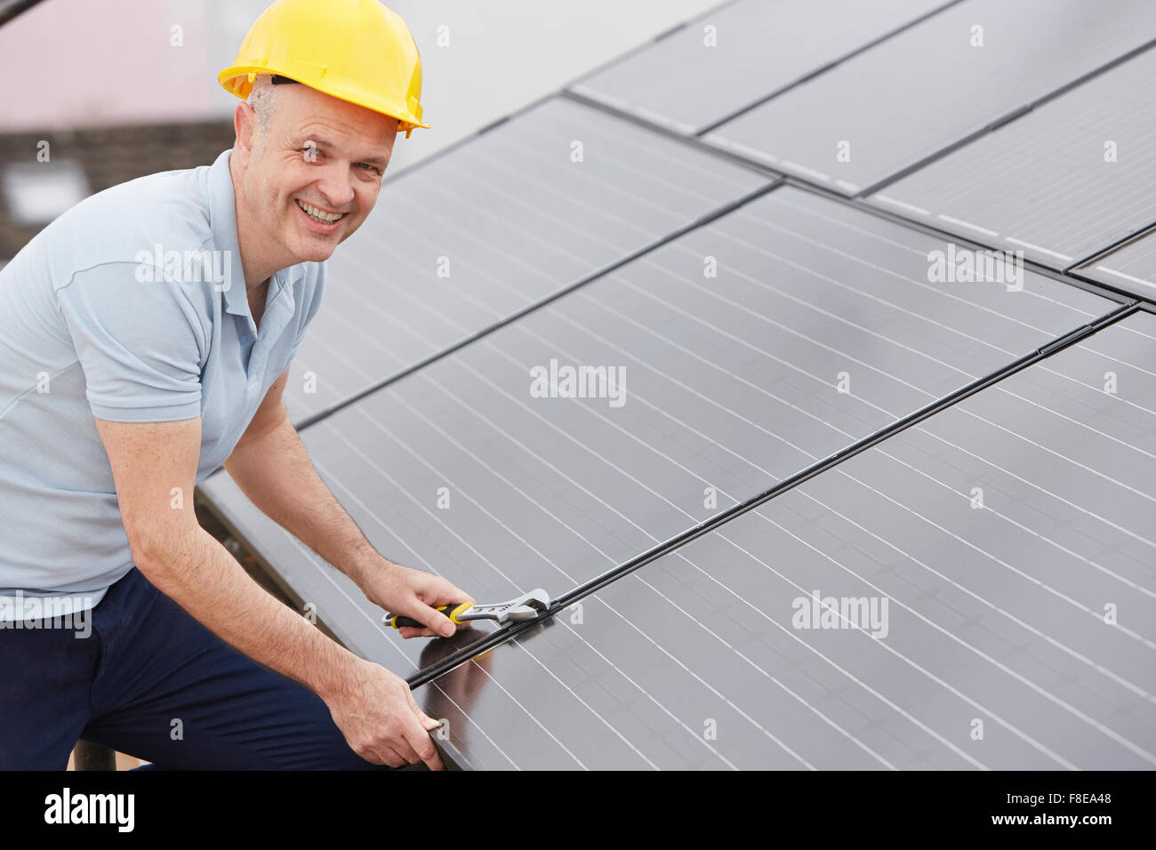Engineer Installing Solar Panels On Roof Of House Stock Photo