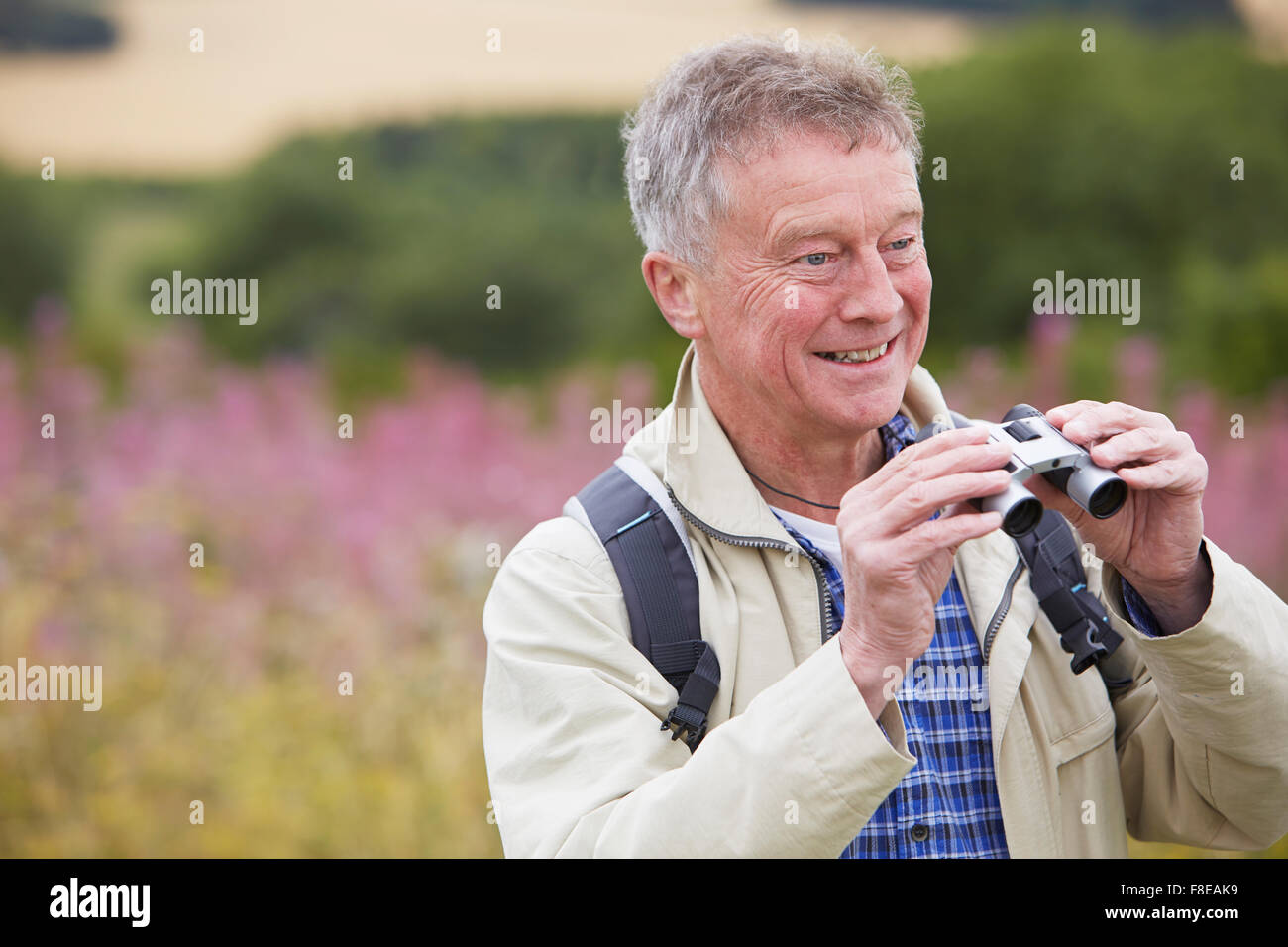 Senior Man On Walk With Binoculars Stock Photo
