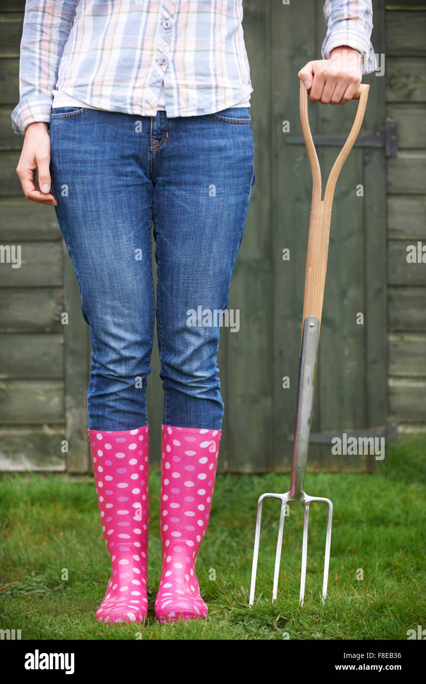 Close Of Woman Wearing Pink Wellingtons Holding Garden Fork Stock Photo