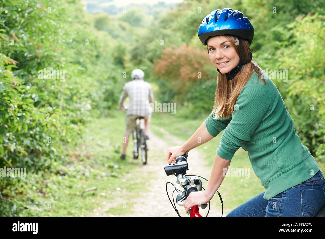 Young Couple Cycling Along Country Track Stock Photo