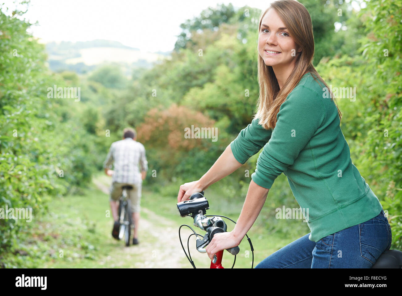 Young Couple Cycling Along Country Track Stock Photo