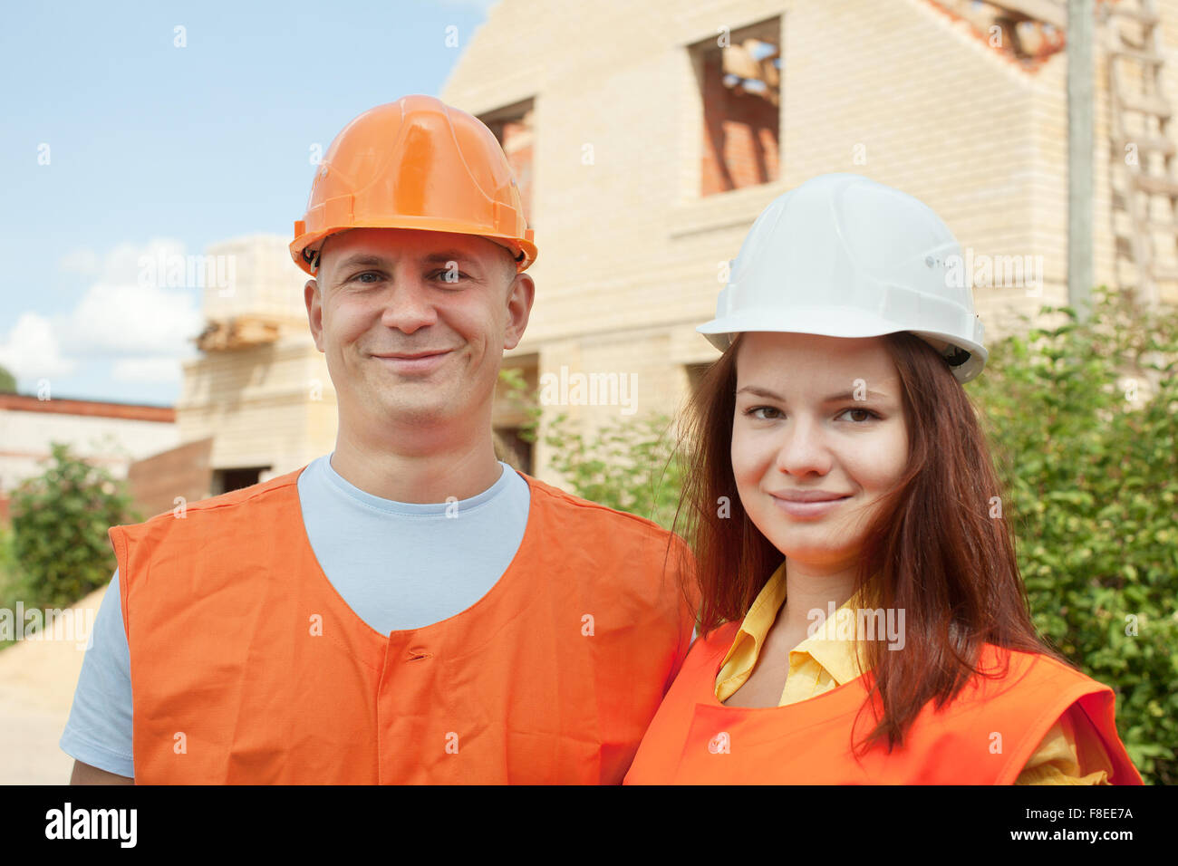 Portrait of two builders works at construction site Stock Photo