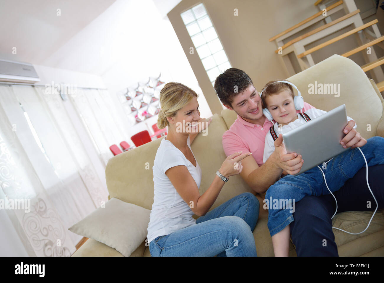 happy young family using tablet computer at modern home for playing ...