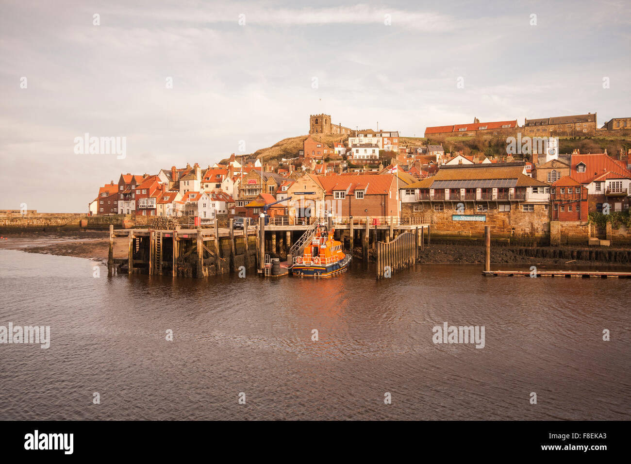 View of the East side of Whitby showing cliff side houses,St.Marys Church and the Whitby lifeboat berthed in the harbour Stock Photo