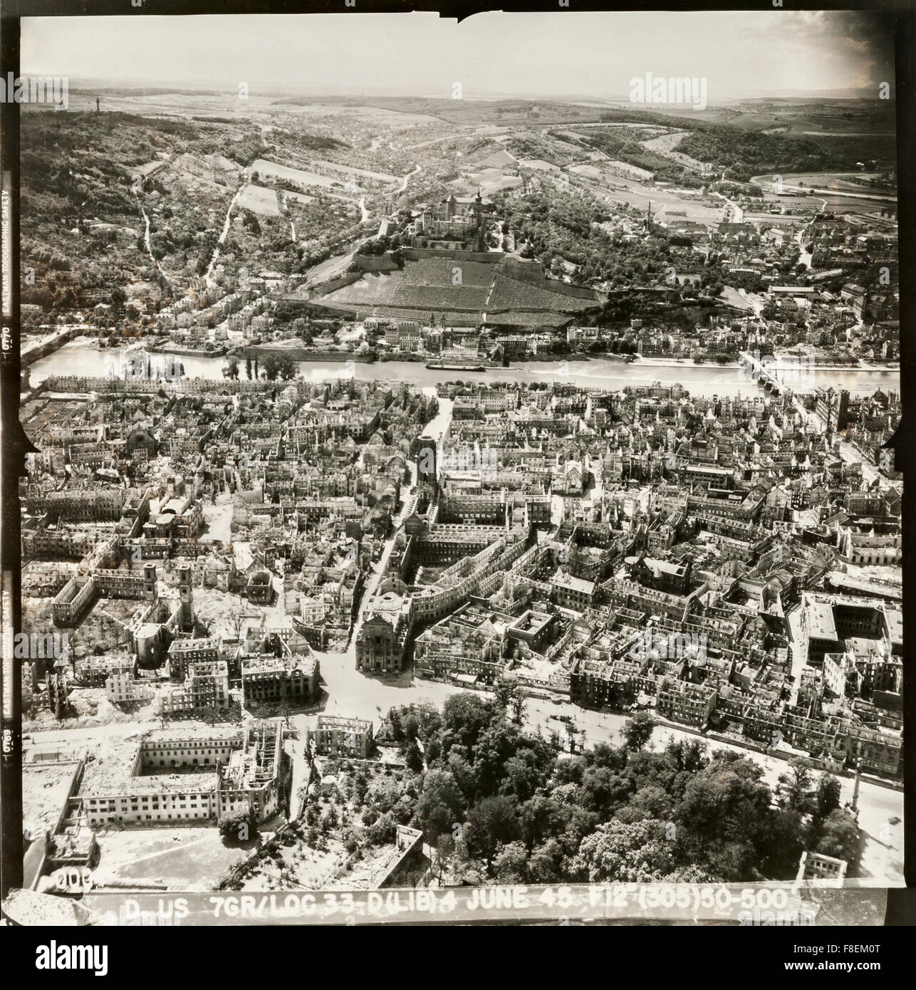 An aerial reconnaissance photograph of the historic German city of Würzburg in ruins after a massive RAF bombing raid on the 16th March 1945. 5000 civilians were killed and 90% of the city was destroyed. This picture was taken in June 1945. It shows the remains of the medieval city centre with the twin towers of Würzburg Cathedral to the left. Beyond the Main River stands Fortress (Festung) Marienberg. Stock Photo