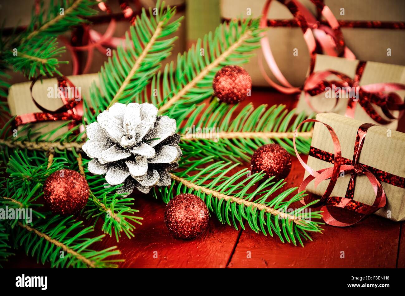 Christmas decoration and gifts. Christmas tree, pine cone, baubles and gifts in the background. Shallow depth of field. Stock Photo