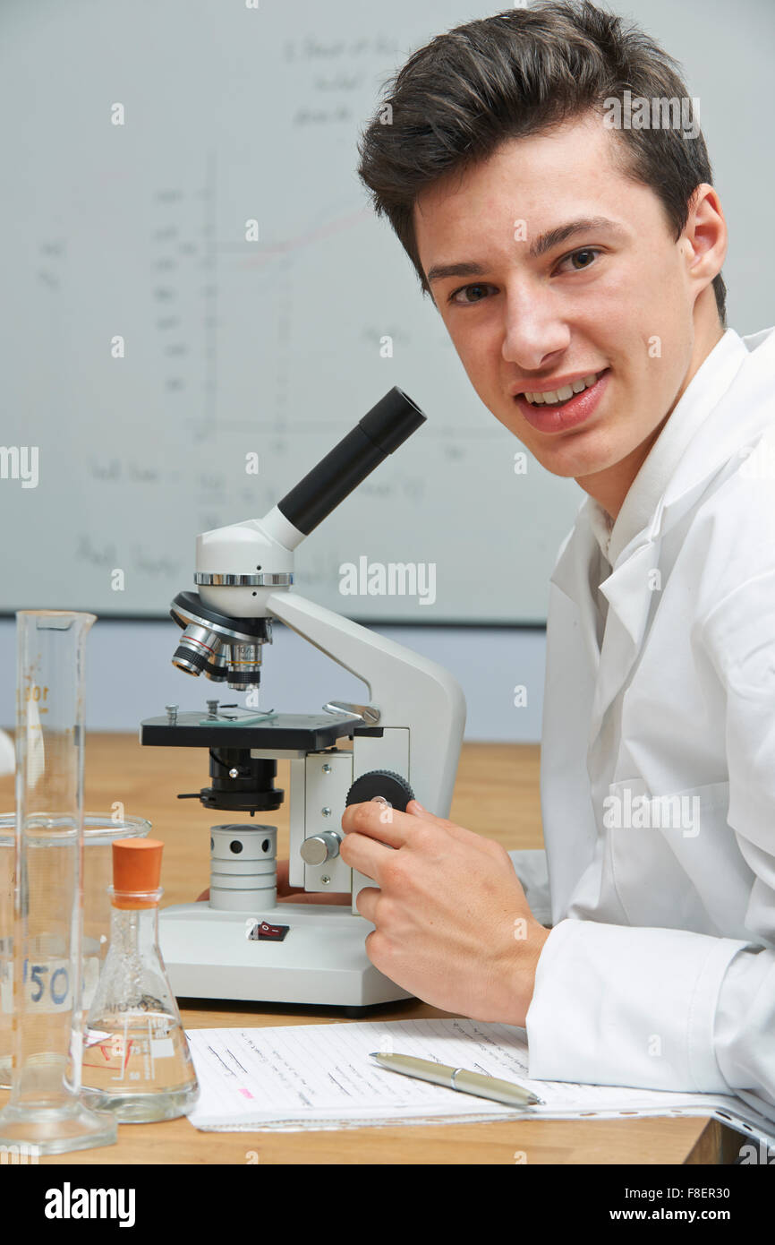 Portrait Of Male Pupil Using Microscope In Science Laboratory Stock 