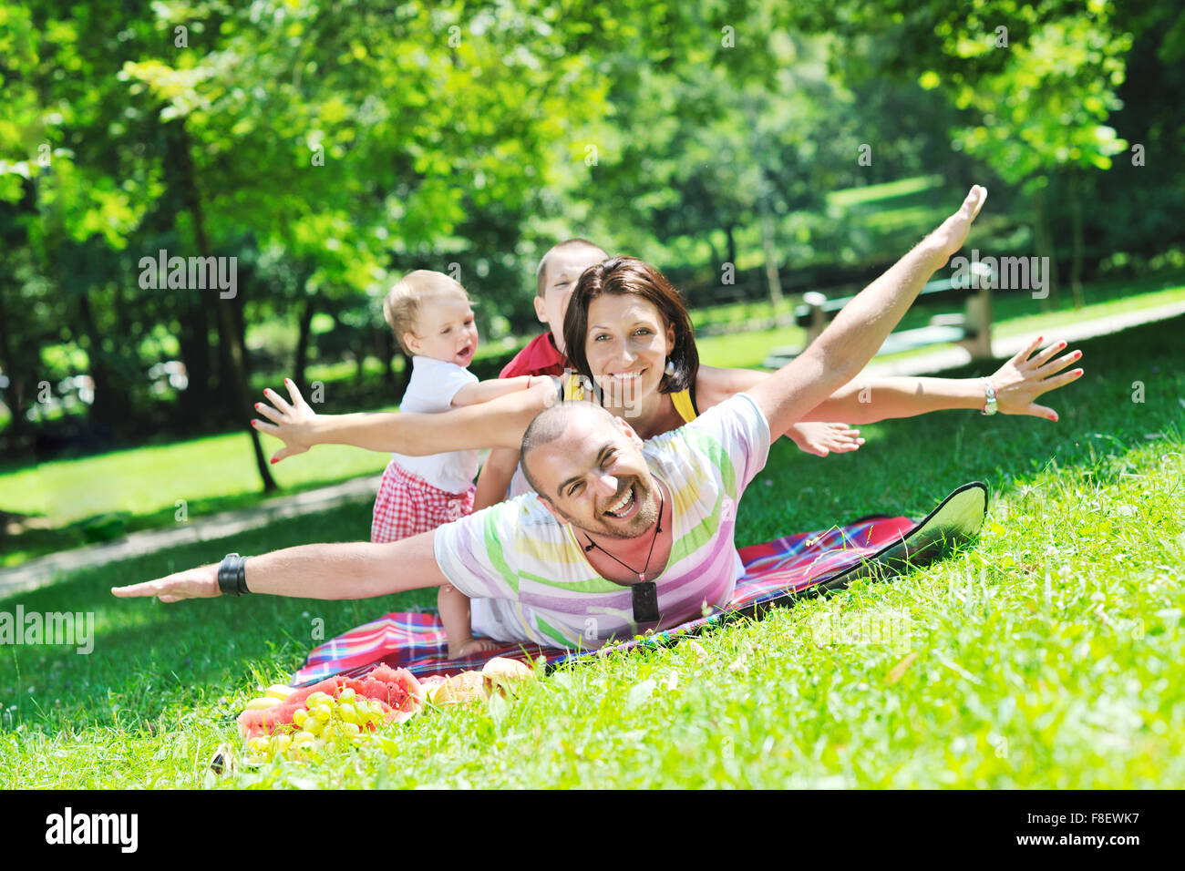happy young couple with their children have fun at beautiful park ...