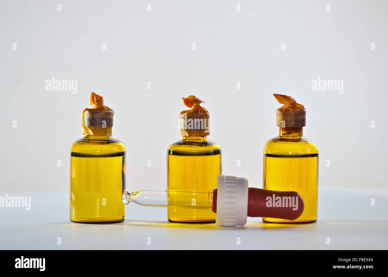 Closeup of three small bottles full of chemicals and a pipette Stock Photo
