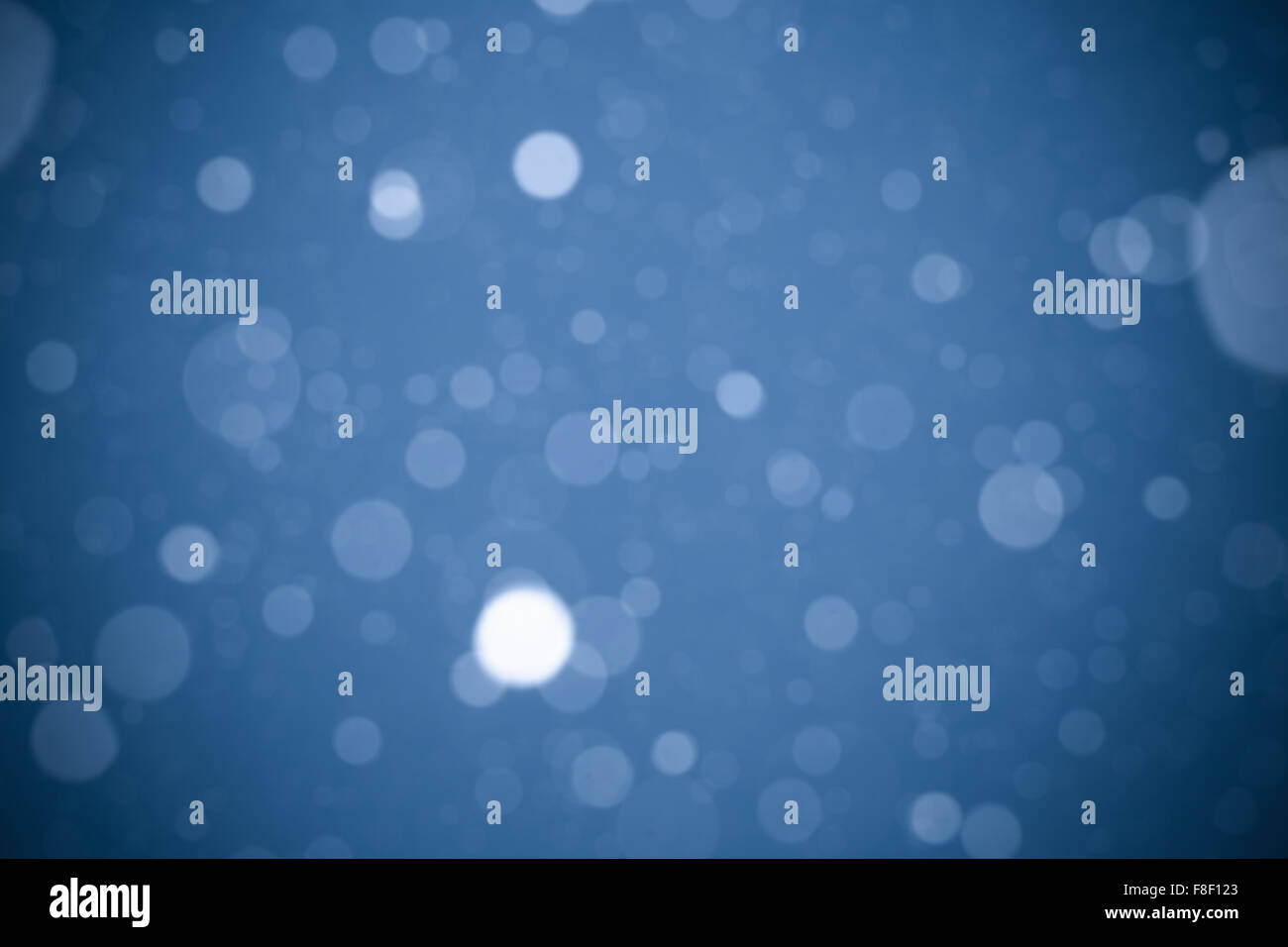Falling snow on blue background Stock Photo - Alamy