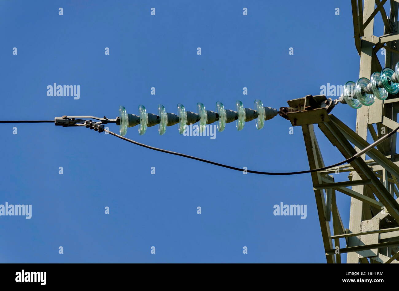 Bell-shaped insulator chain of electric power transmission line, Bulgaria Stock Photo