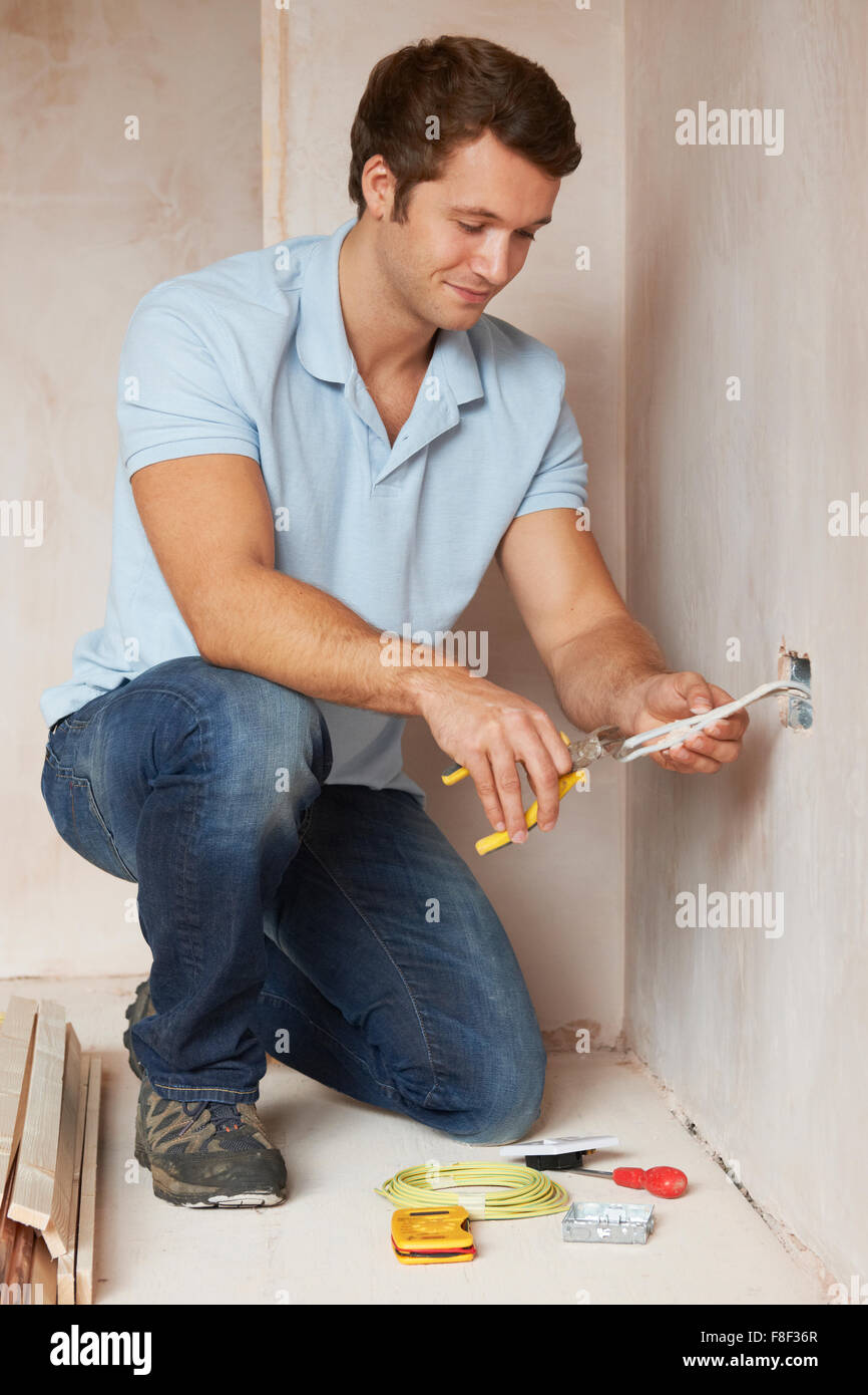 Electrician Installing Socket In New House Stock Photo