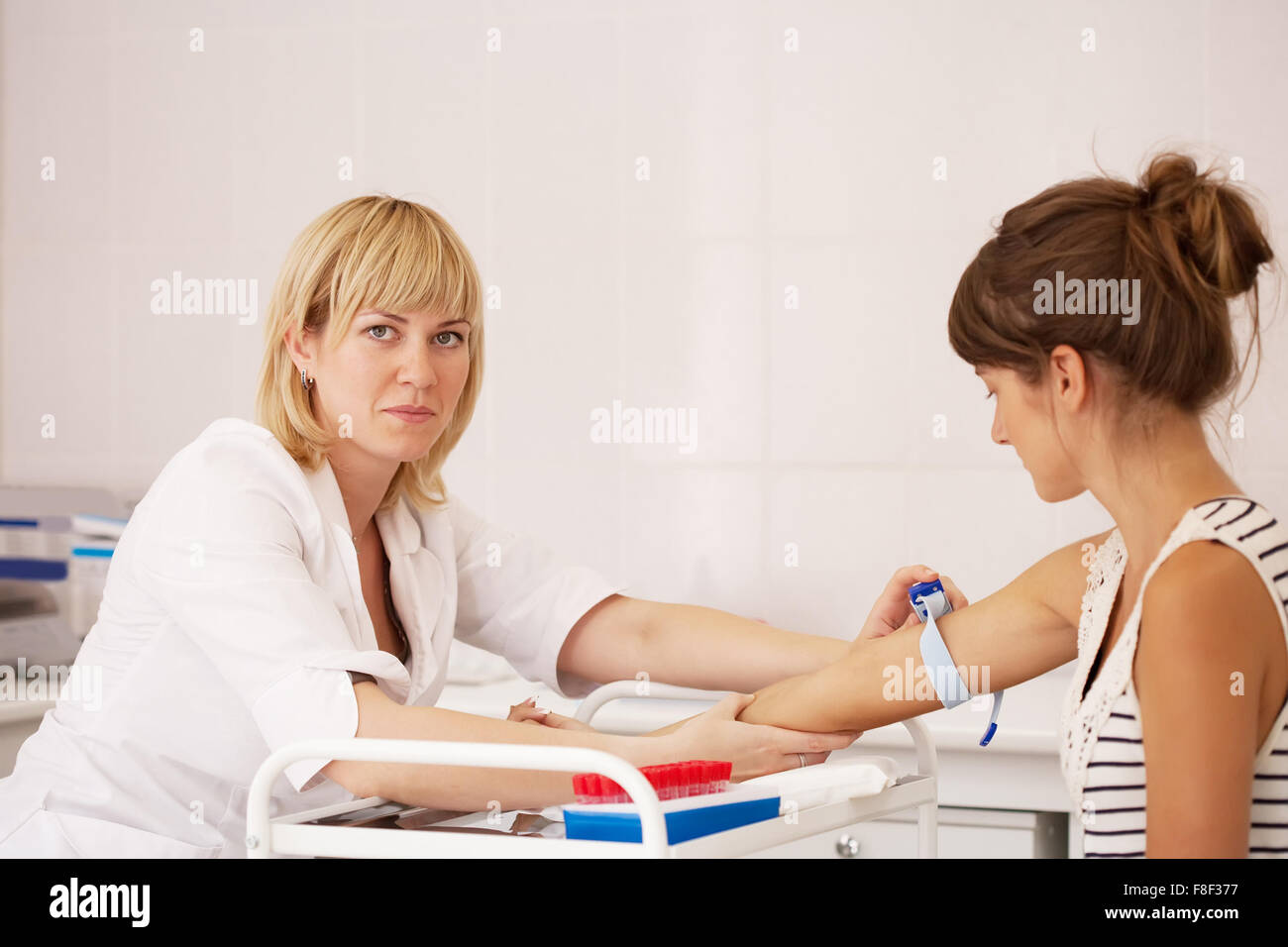 Врач берущий кровь. Девушка сдает анализы. Медсестра берет кровь из вены. Лицо виче категорийное ВИЧ.