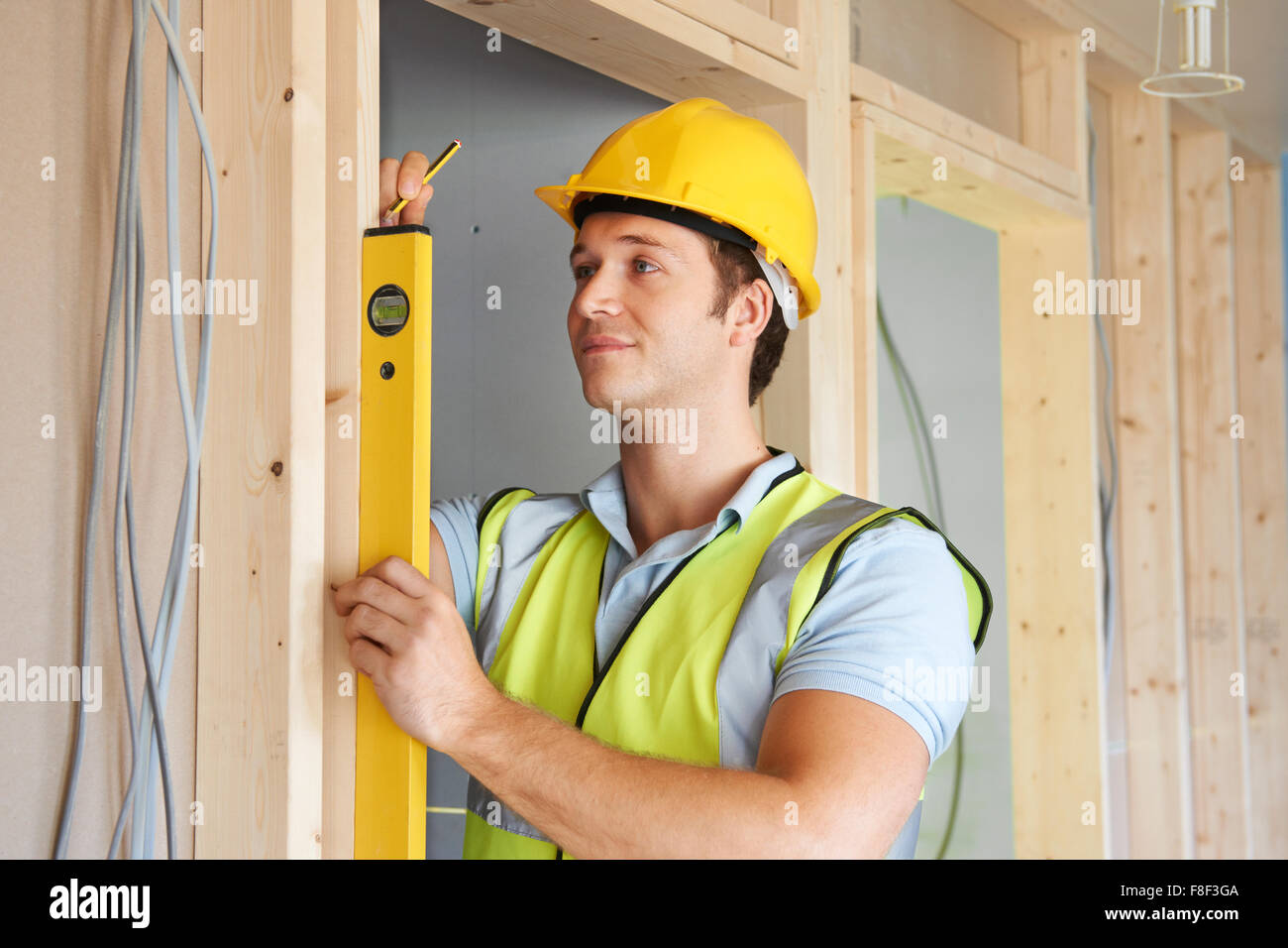 Builder Checking Work With Spirit Level Stock Photo - Alamy