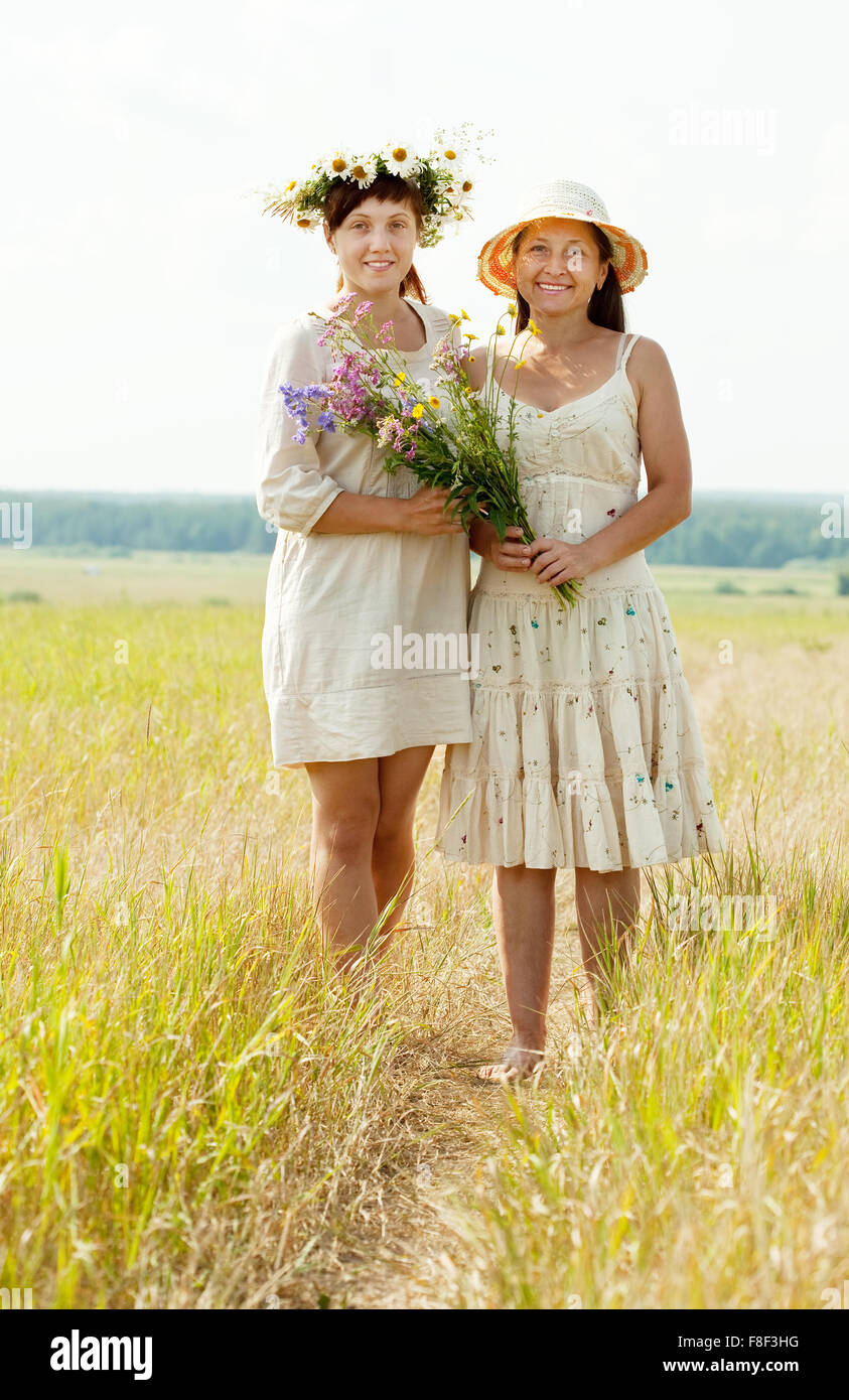 Portrait of two happy women with flowers in summer field Stock Photo ...
