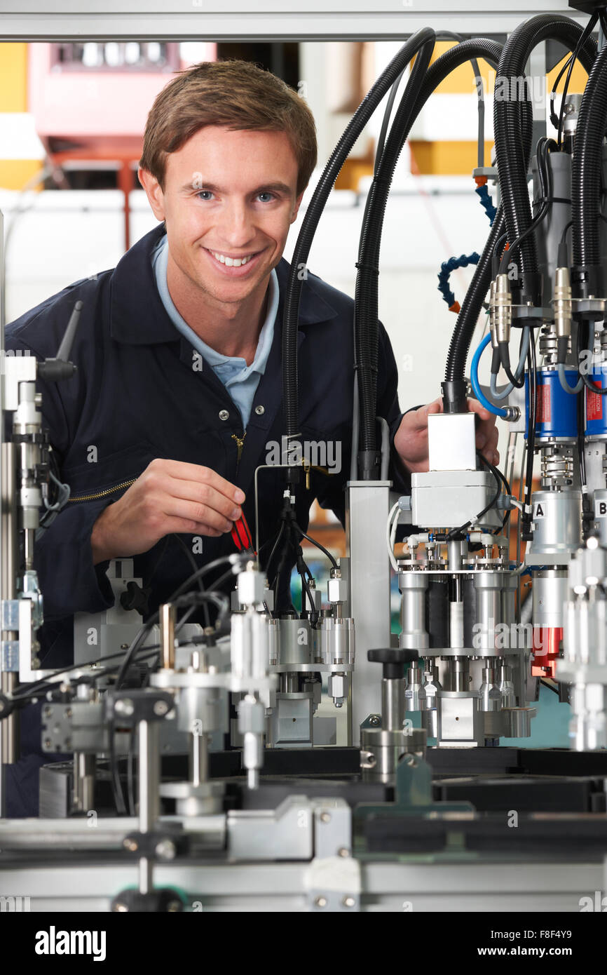 Engineer Working On Complex Equipment In Factory Stock Photo