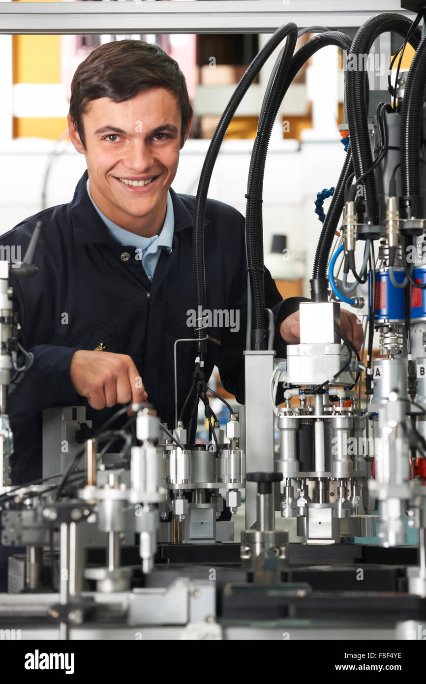 Trainee Engineer Working On Machinery In Factory Stock Photo