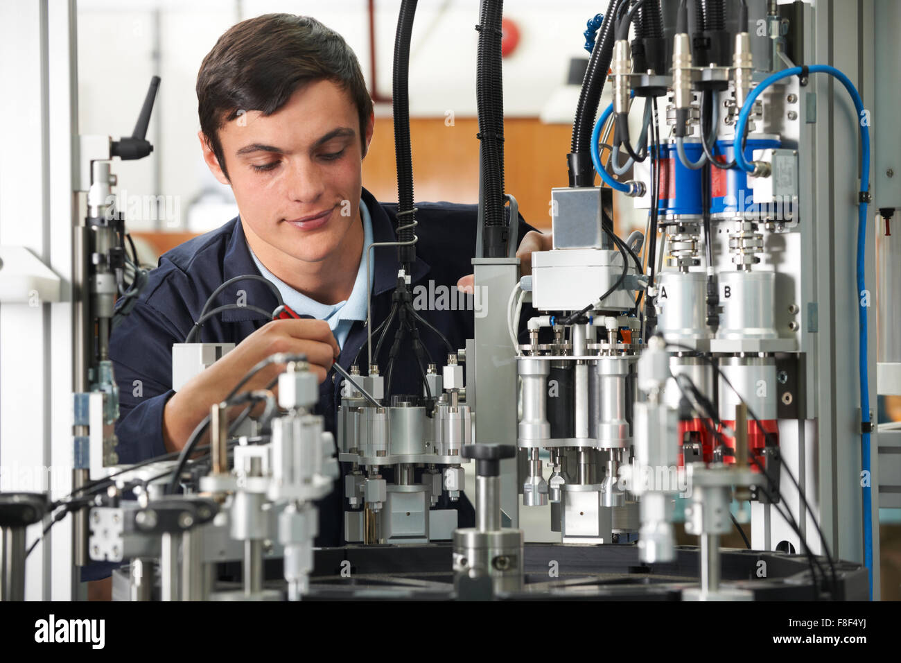 Trainee Engineer Working On Machinery In Factory Stock Photo