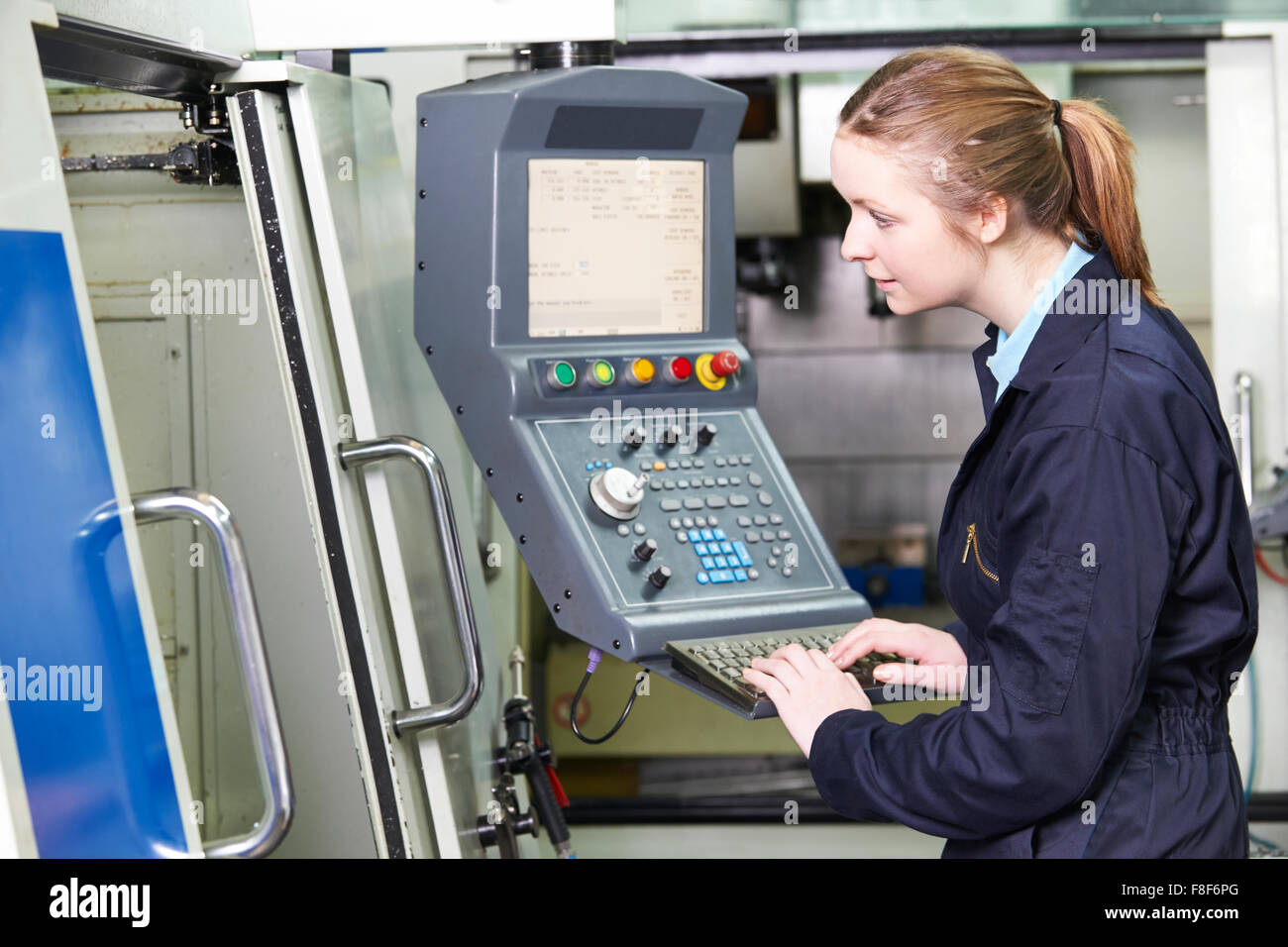 Female Engineer Operating Computer Controlled Cutting Machine Stock