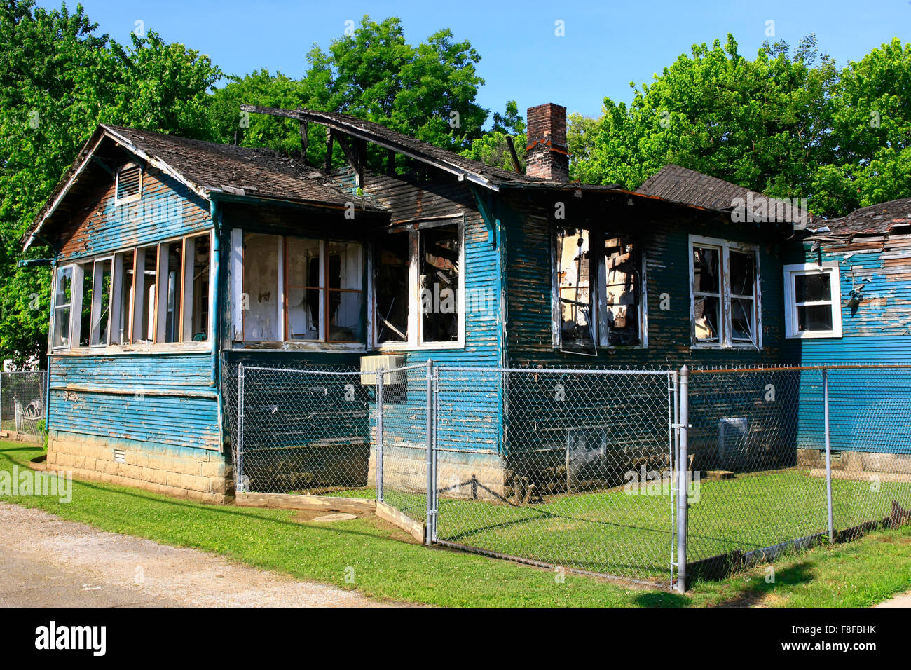 The burnt out shell of a home now surrounded by fencing before it's ...