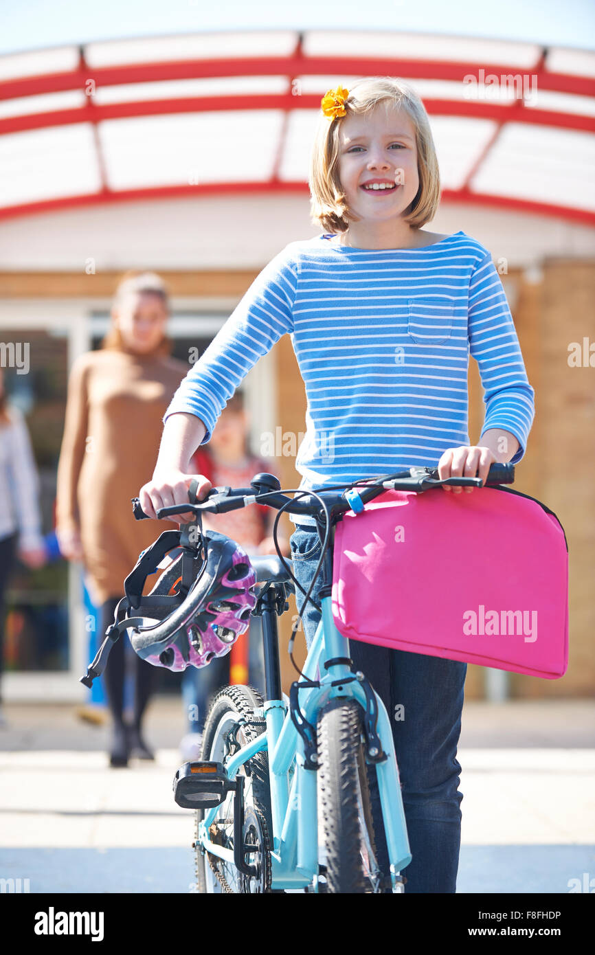 Female Pupil Pushing Bike At End Of School Day Stock Photo