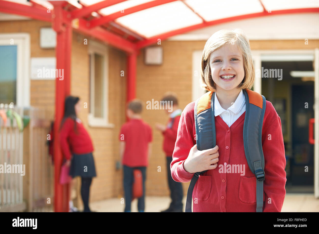 Girl Wearing Uniform Standing In School Playground Stock Photo