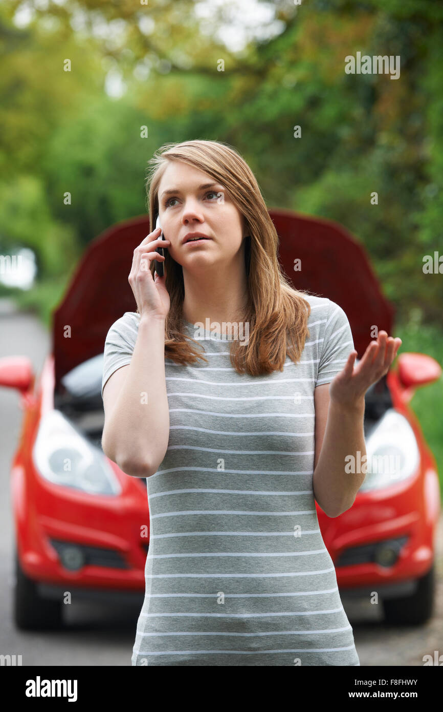 Female Motorist Phoning For Help After Breakdown Stock Photo