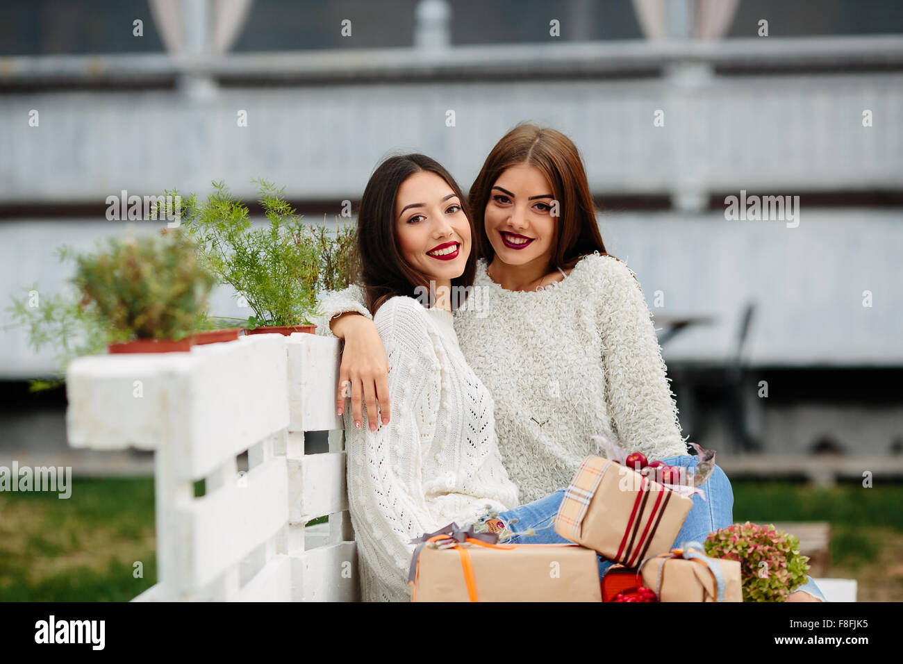 Two beautiful girls sitting on a bench Stock Photo - Alamy