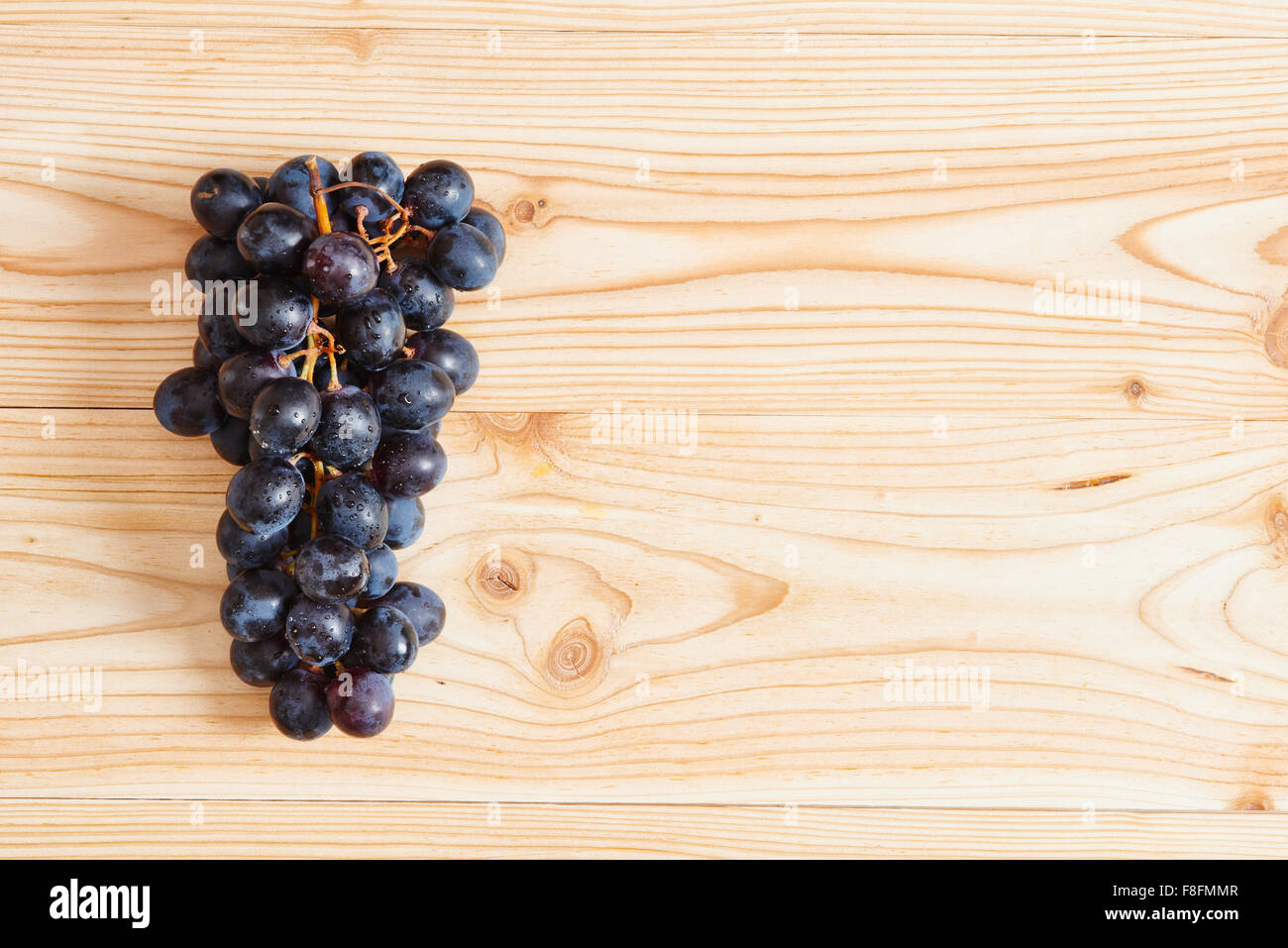 Bunch of red grapes on wooden table Stock Photo