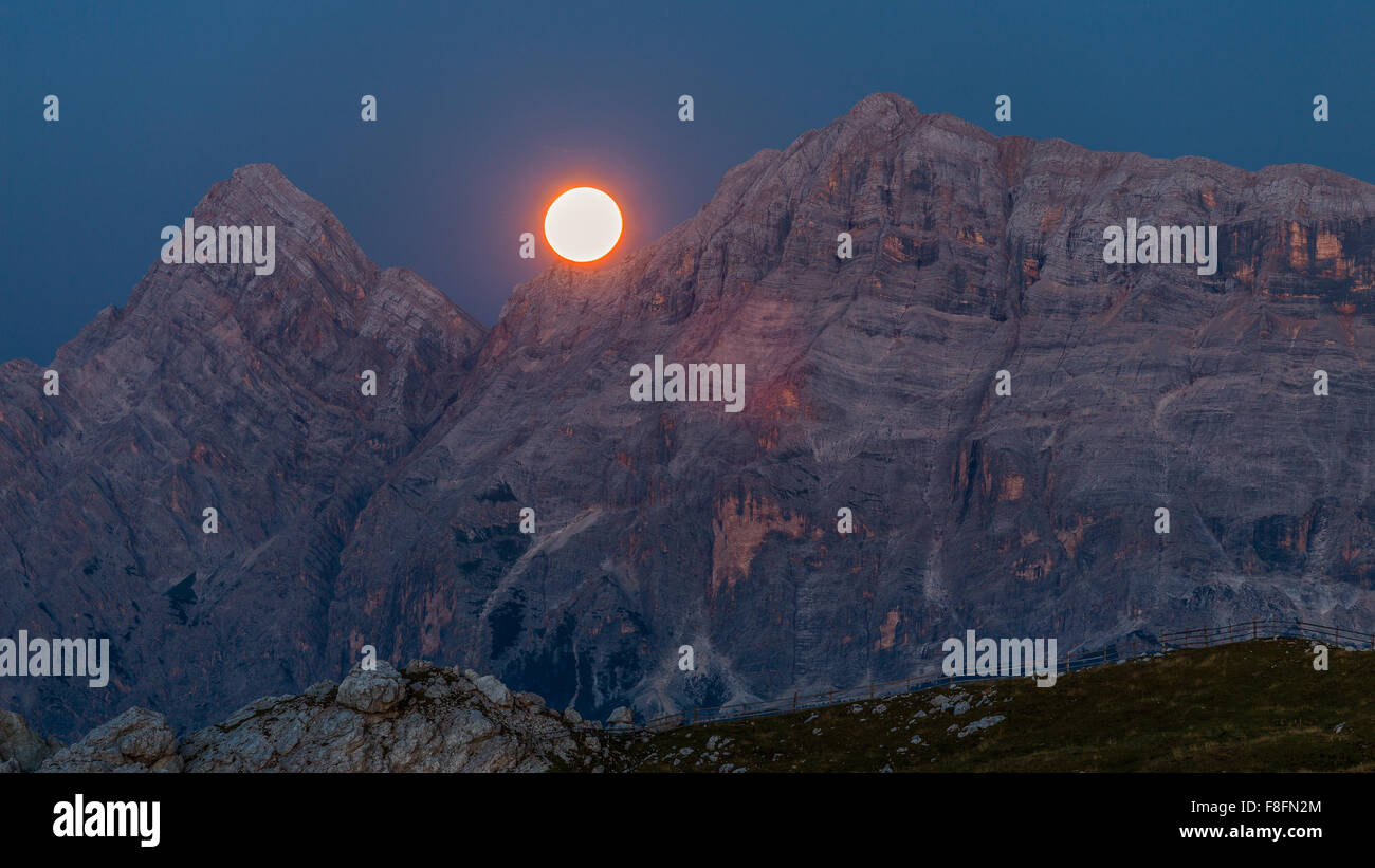Moon between Mount Sas Dles Nu (Sasso delle Nove) and Mt. Sas Dles Diesc (Sasso delle Dieci). The Badia Valley. The Dolomites Stock Photo