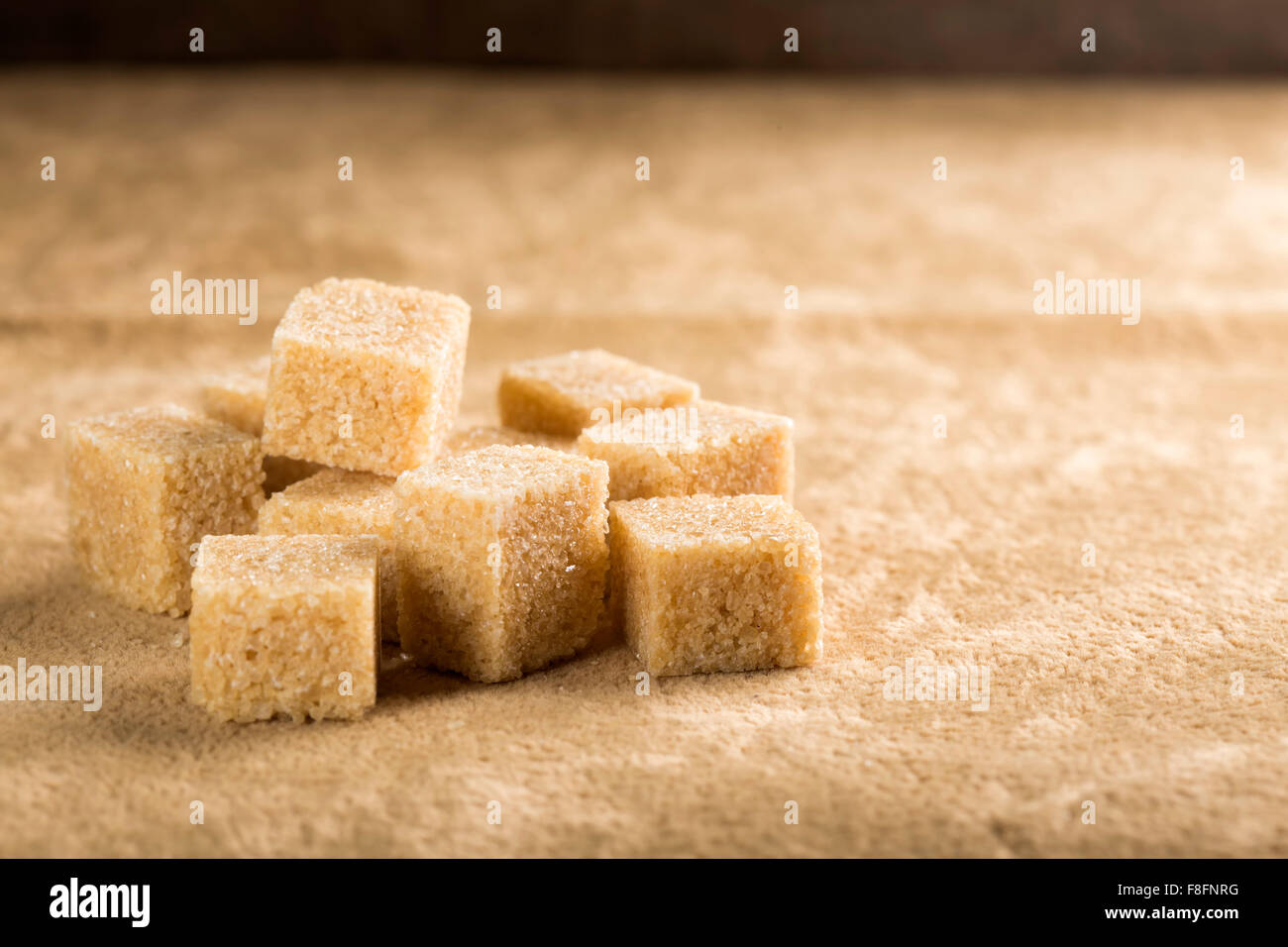 Brown cane sugar cubes on a brown background Stock Photo