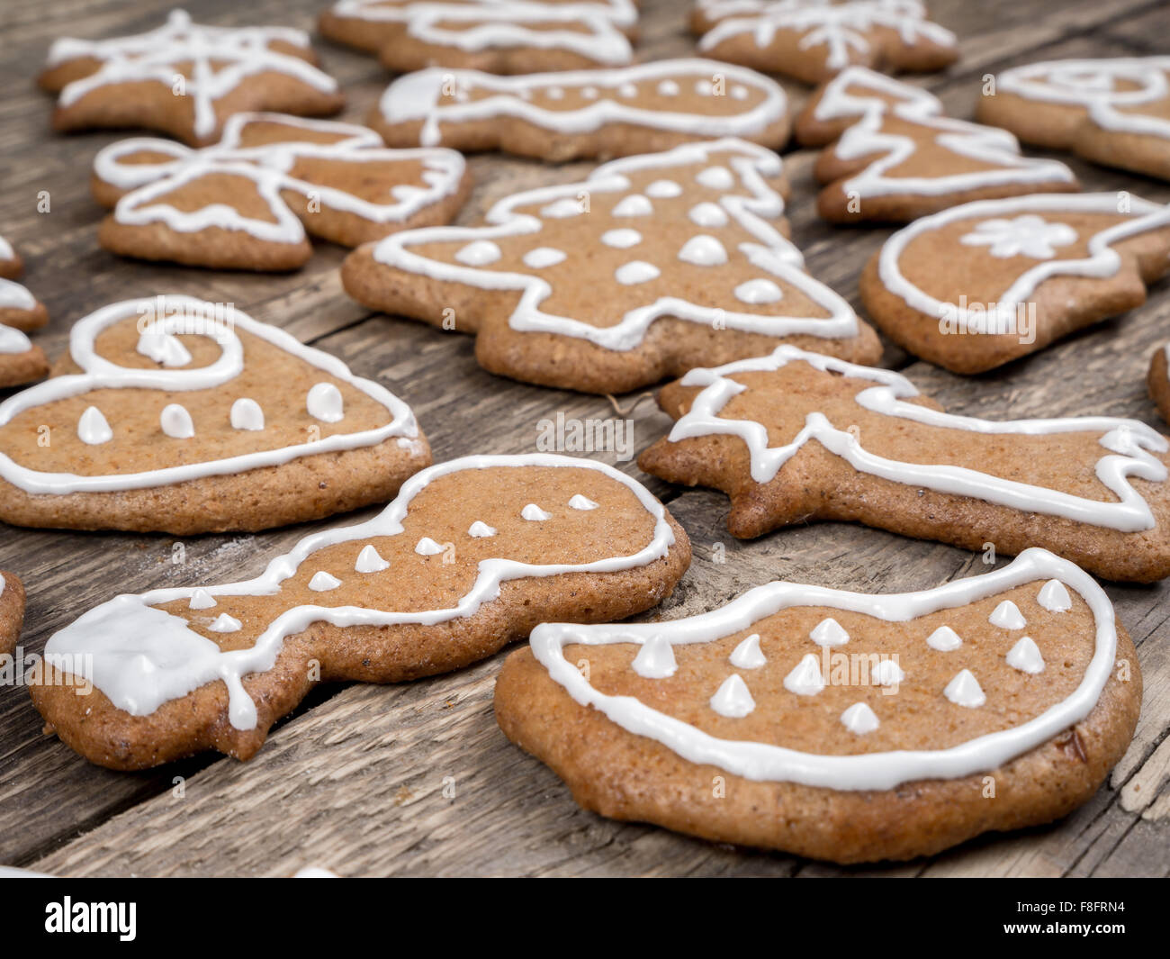 Different shape Christmas gingerbread cookies with white icing placed on wooden rustic boards Stock Photo