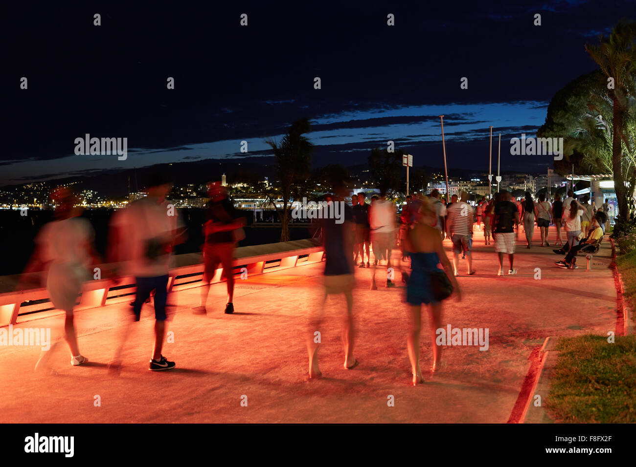 People walking in a summer night along the Croisette boulevard in Cannnes Stock Photo