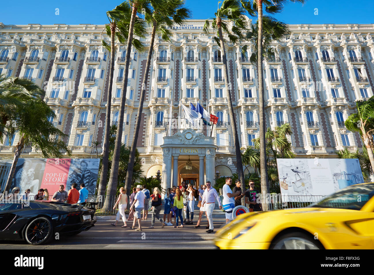 People walking and luxury cars passing in front the luxury hotel InterContinental Carlton, located on La Croisette boulevard Stock Photo