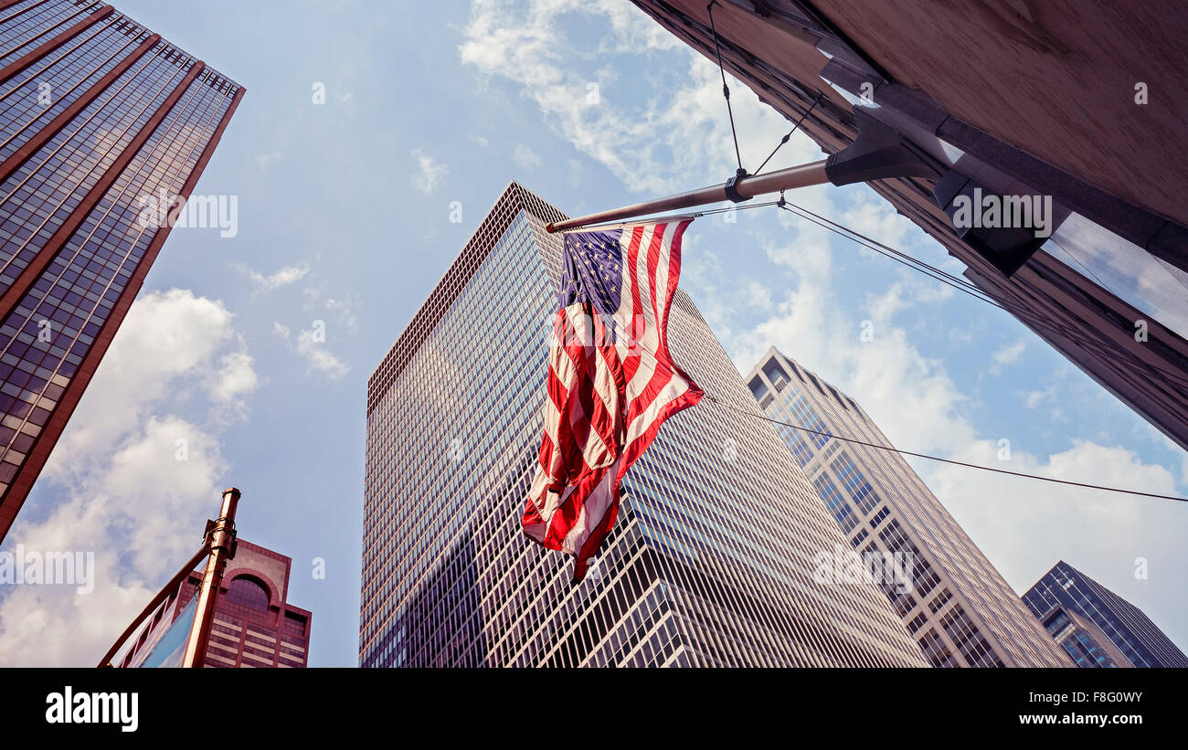 Vintage toned American flag and skyscrapers in Manhattan, New York City, USA. Stock Photo