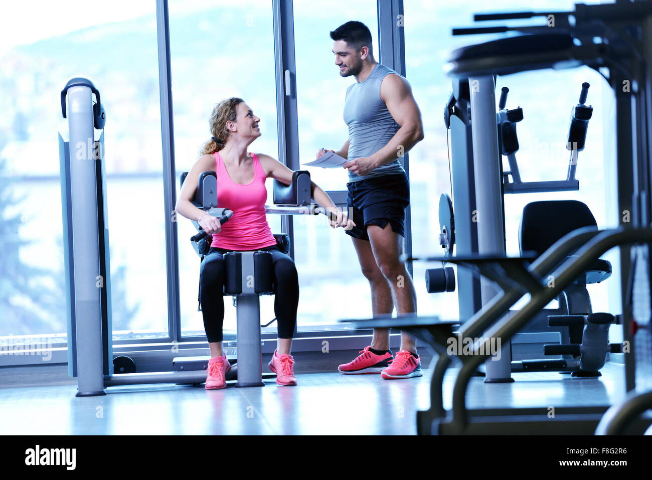 Gym woman exercising with her personal trainer Stock Photo - Alamy