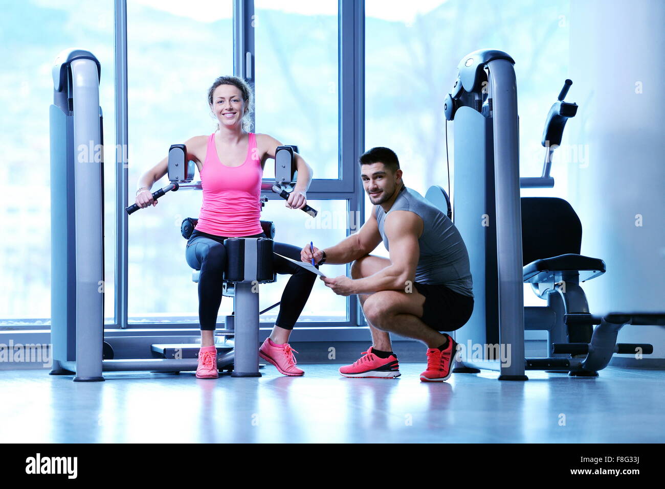 Gym woman exercising with her personal trainer Stock Photo - Alamy