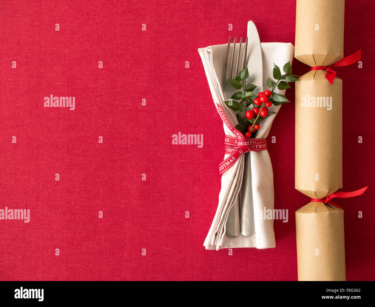 Christmas cracker and cutlery kitchenware on  red tablecloth background food concept Stock Photo