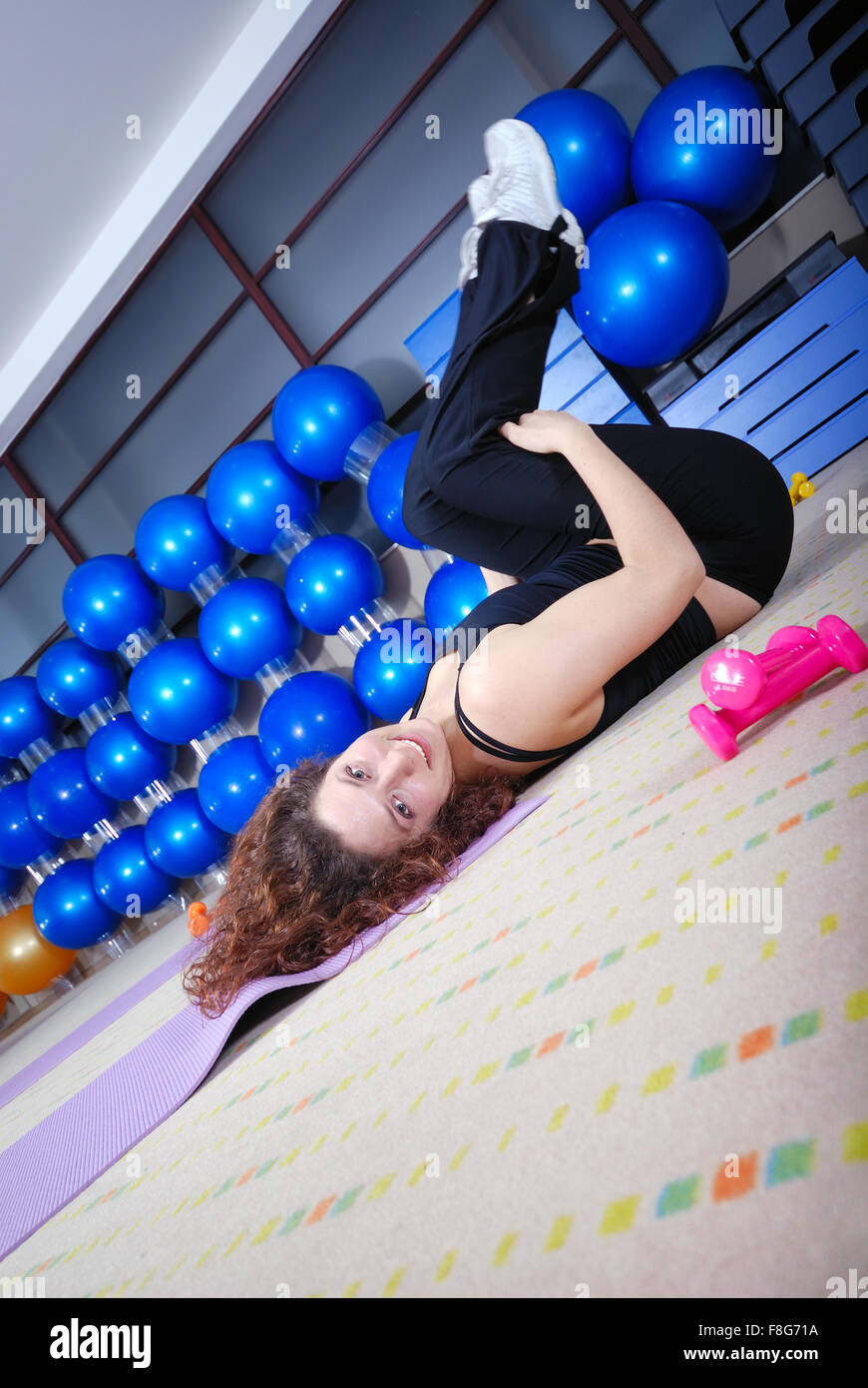 pretty girl warming up andd streching in fitness studio Stock Photo
