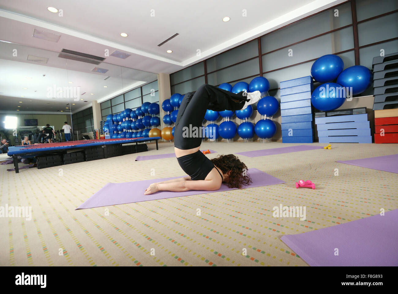 pretty girl warming up andd streching in fitness studio Stock Photo