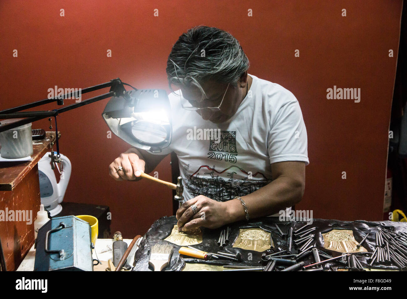 A craftsman working on a metal engraving in Calle La Ronda in Old Town Quito, Ecuador. Stock Photo